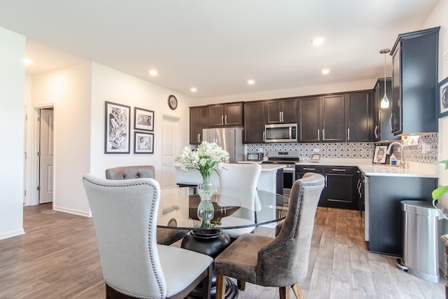 dining space with recessed lighting, light wood finished floors, and baseboards