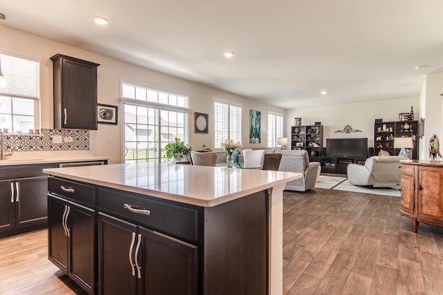 kitchen with a sink, a center island, recessed lighting, and light wood finished floors