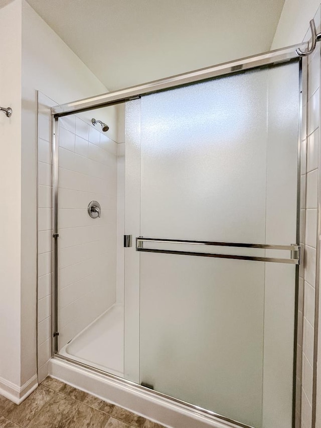 bathroom with baseboards and a shower stall
