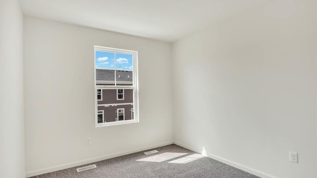 spare room featuring visible vents, carpet, and baseboards