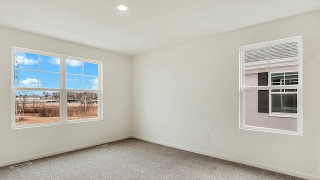 unfurnished room with recessed lighting, baseboards, light colored carpet, and visible vents
