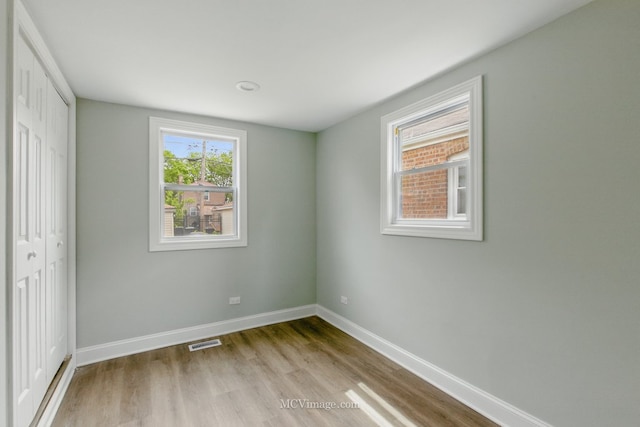 8907 S Luella Ave, Chicago, IL 60617 - unfurnished bedroom featuring wood finished floors, a closet, and baseboards
