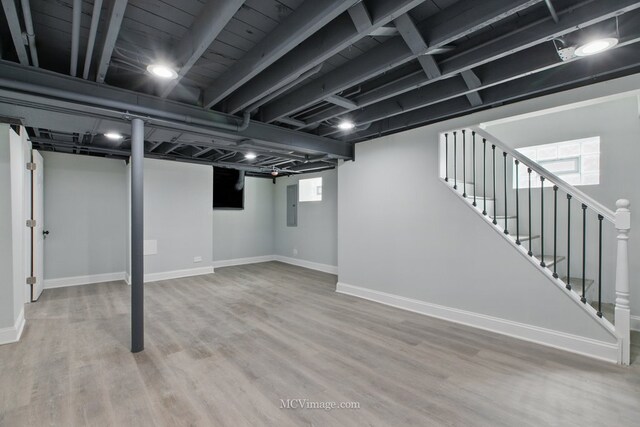 8907 S Luella Ave, Chicago, IL 60617 - below grade area featuring electric panel, baseboards, stairs, and wood finished floors