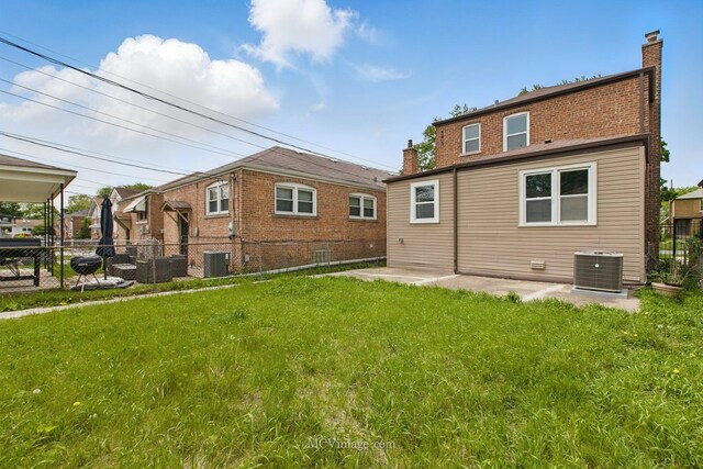 8907 S Luella Ave, Chicago, IL 60617 - rear view of house featuring central AC unit, a chimney, and a patio area