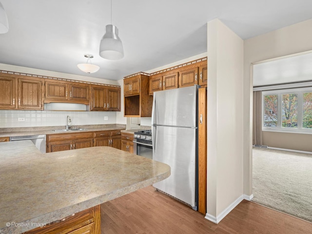 8920 Sycamore Dr, Hickory Hills, IL 60457 - kitchen featuring appliances with stainless steel finishes, brown cabinets, a sink, baseboards, and light countertops