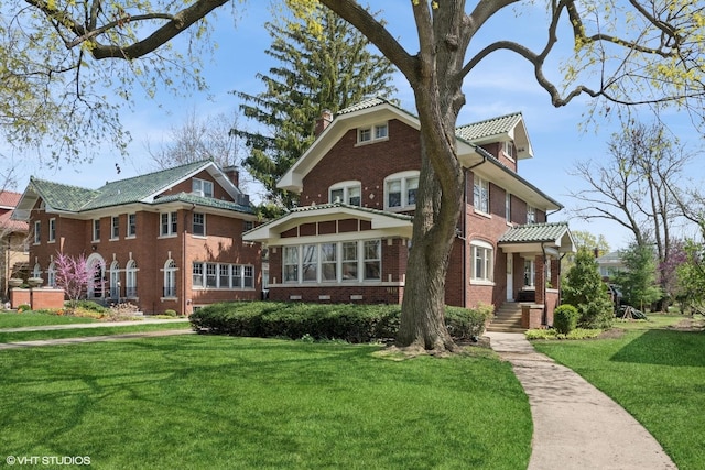 view of front facade with brick siding and a front yard