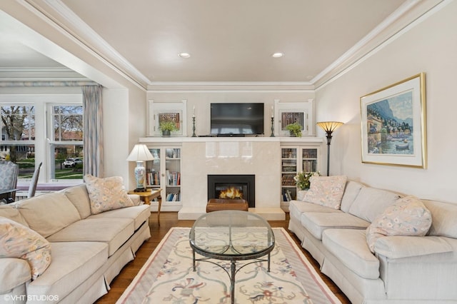 living area with crown molding, a fireplace, recessed lighting, and wood finished floors