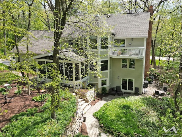 42W142 Ravine Dr, Saint Charles, IL 60175 - rear view of house with a shingled roof, a chimney, a sunroom, a balcony, and a patio area