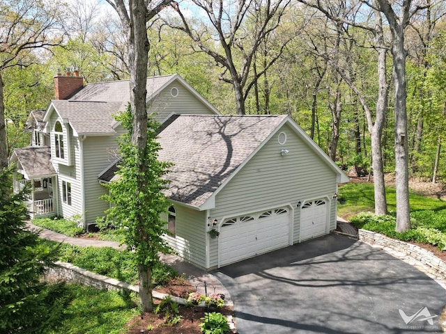 42W142 Ravine Dr, Saint Charles, IL 60175 - view of home's exterior with a shingled roof, asphalt driveway, a garage, and a chimney
