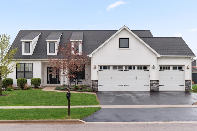 840 Coventry Cir N, Sycamore, IL 60178 - modern farmhouse style home with stone siding, a shingled roof, a front yard, and aphalt driveway