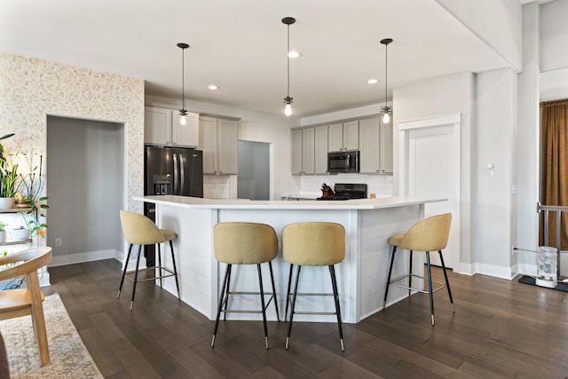 840 Coventry Cir N, Sycamore, IL 60178 - kitchen with light countertops, a kitchen breakfast bar, black appliances, backsplash, and gray cabinetry