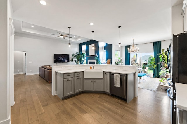 840 Coventry Cir N, Sycamore, IL 60178 - kitchen featuring a sink, dishwashing machine, open floor plan, a raised ceiling, and gray cabinetry