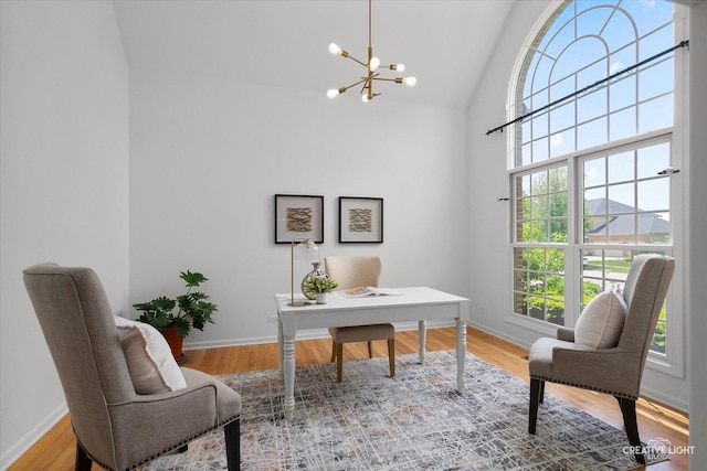 office area with a chandelier, baseboards, wood finished floors, and high vaulted ceiling