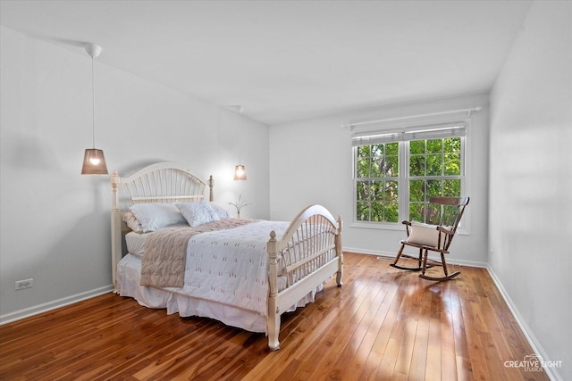 bedroom with wood-type flooring and baseboards