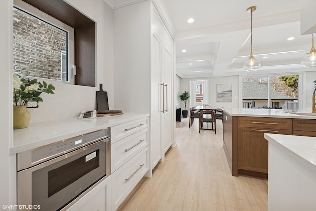 kitchen featuring beam ceiling, light wood-type flooring, white cabinetry, stainless steel microwave, and coffered ceiling