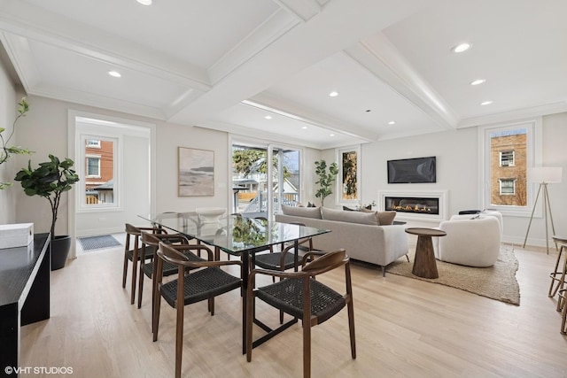 dining area featuring recessed lighting, beamed ceiling, a glass covered fireplace, and light wood finished floors