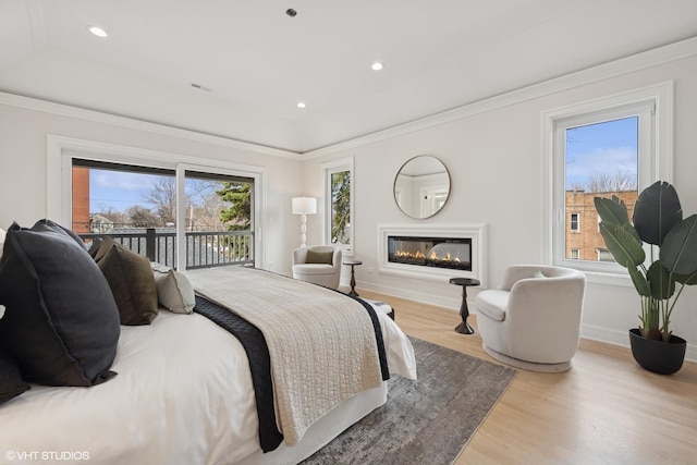 bedroom featuring access to outside, baseboards, multiple windows, and wood finished floors