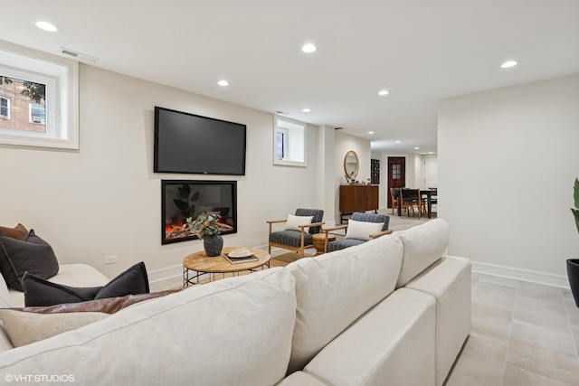 living area featuring baseboards, recessed lighting, and visible vents