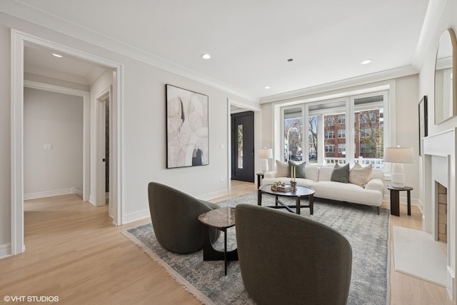 living area featuring baseboards, recessed lighting, light wood-style flooring, and a fireplace