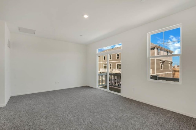 unfurnished room featuring baseboards and dark carpet