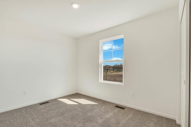 spare room with visible vents, carpet flooring, and baseboards