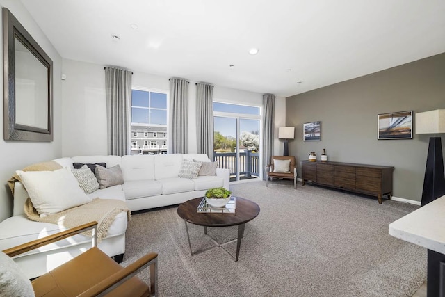 carpeted living area featuring recessed lighting and baseboards