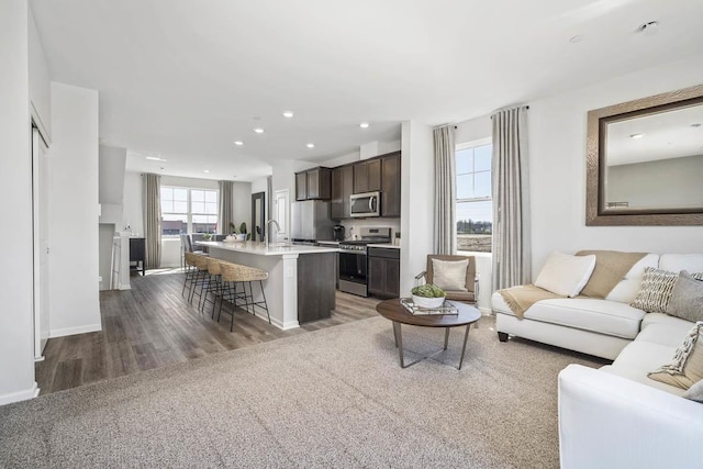 living room featuring baseboards, recessed lighting, and wood finished floors