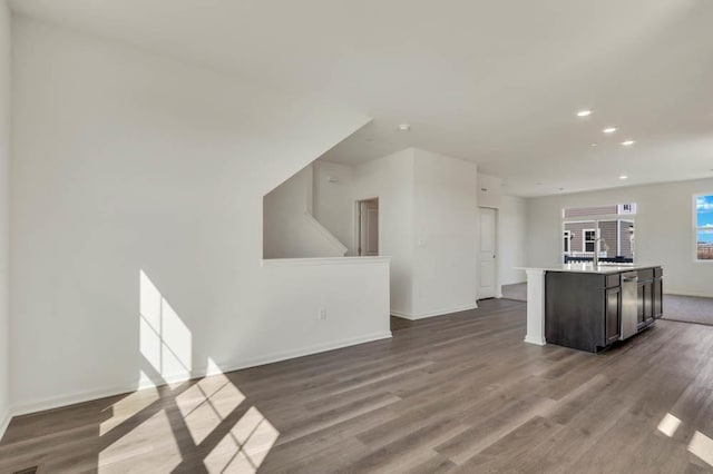 kitchen with dark wood-style flooring, recessed lighting, baseboards, and a sink