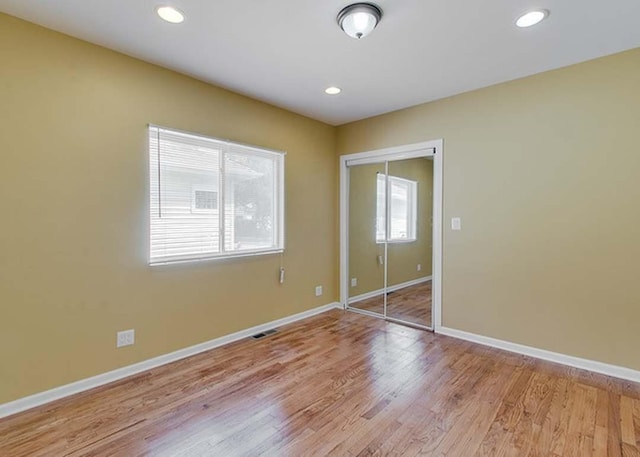 unfurnished bedroom with visible vents, baseboards, a closet, and light wood-type flooring
