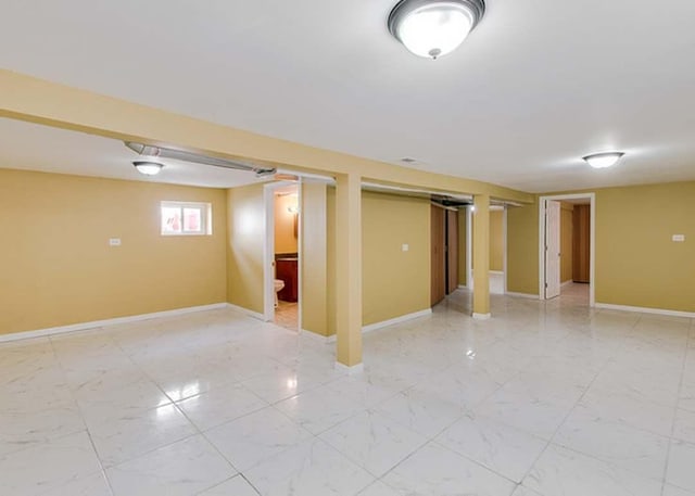 below grade area featuring baseboards and marble finish floor