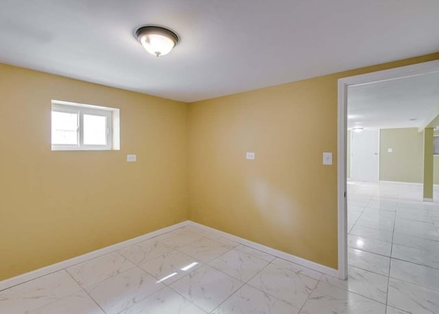 spare room with baseboards and marble finish floor