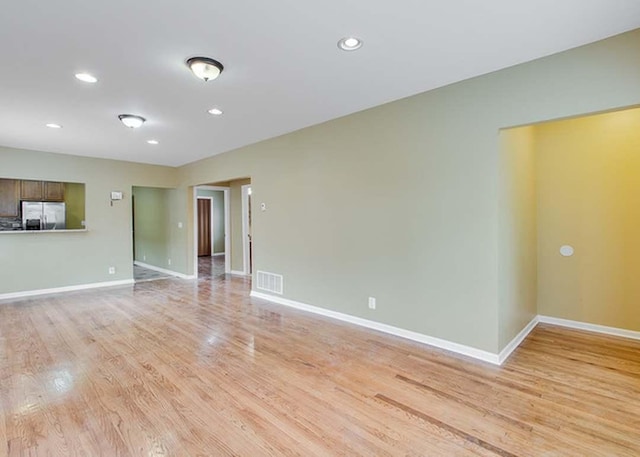 unfurnished living room featuring recessed lighting, baseboards, light wood-type flooring, and visible vents
