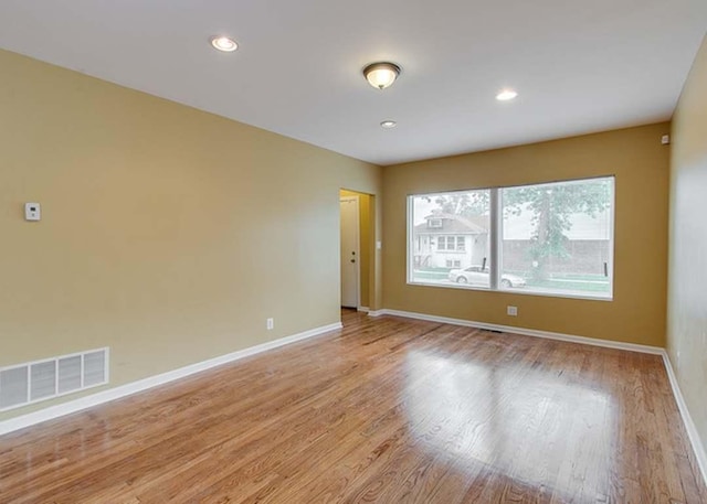 spare room featuring visible vents, light wood-style flooring, baseboards, and recessed lighting