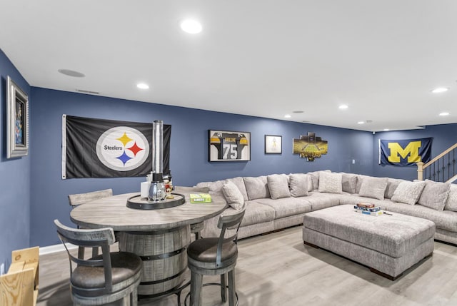 living area featuring light wood-style floors, recessed lighting, and stairs