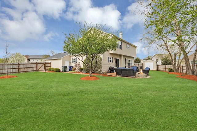 back of house featuring a storage unit, a fenced backyard, and a yard