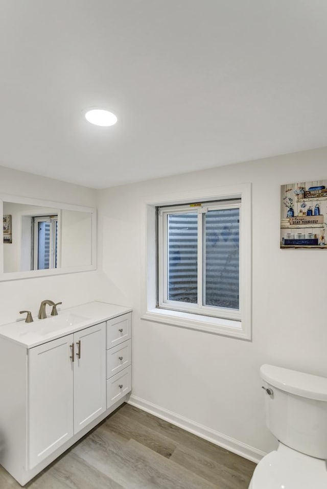 bathroom featuring vanity, baseboards, toilet, and wood finished floors