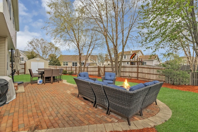 view of patio featuring outdoor dining area, a residential view, an outdoor structure, a storage unit, and a fire pit