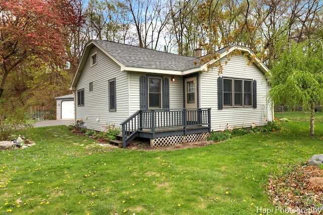 single story home with a chimney, a detached garage, fence, a front lawn, and a shingled roof