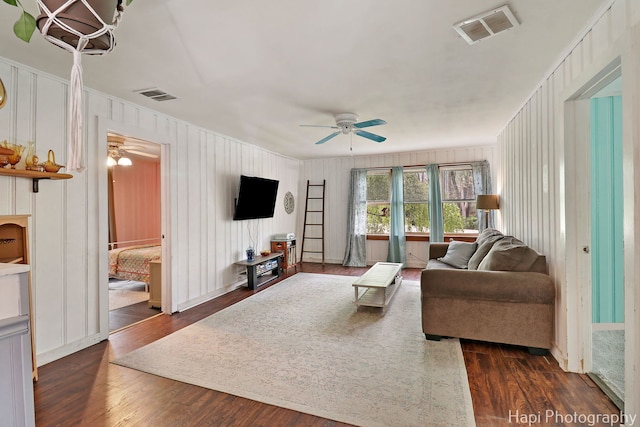 living area with visible vents, dark wood-style flooring, and ceiling fan
