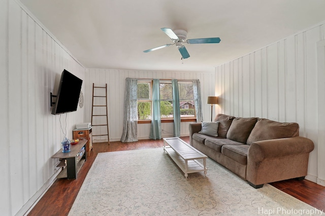 living area featuring a ceiling fan and dark wood-style flooring