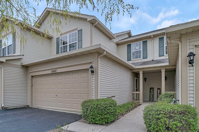 view of front facade featuring an attached garage and aphalt driveway
