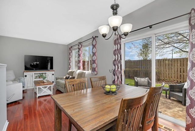 dining area featuring visible vents, dark wood-style flooring, and a chandelier