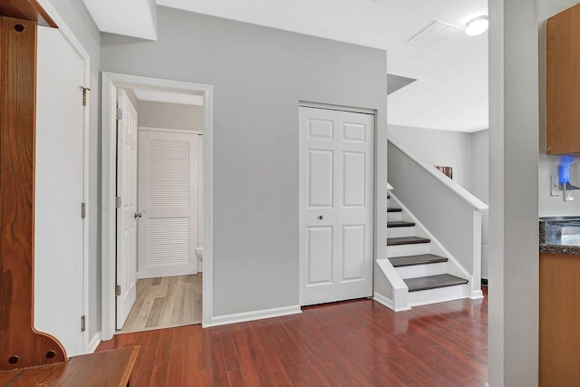 stairs with visible vents, baseboards, and wood finished floors