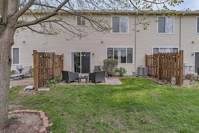 back of house featuring fence, cooling unit, a patio, an outdoor living space, and a lawn