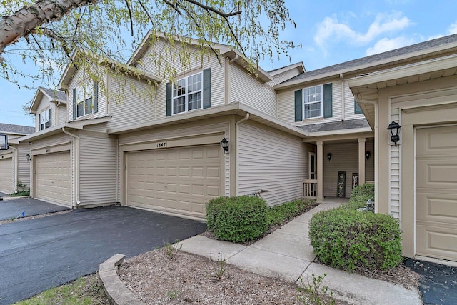 view of property featuring aphalt driveway and a garage