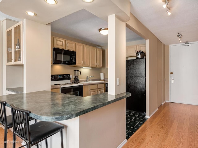 405 N Wabash Ave Unit 2315, Chicago, IL 60611 - kitchen featuring light brown cabinetry, dark countertops, dark wood-style floors, a sink, and black appliances
