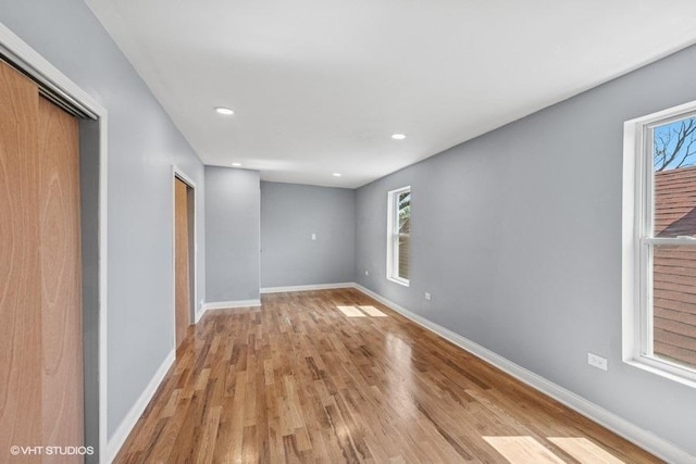 spare room featuring recessed lighting, baseboards, and light wood-type flooring