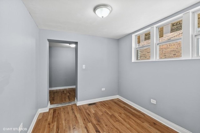 interior space featuring baseboards, visible vents, and wood finished floors