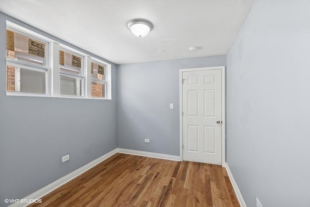 empty room with baseboards and wood finished floors