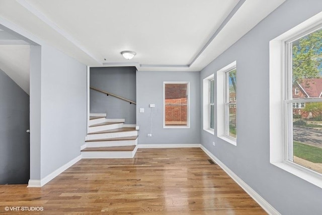 interior space with baseboards, stairs, wood finished floors, and a wealth of natural light